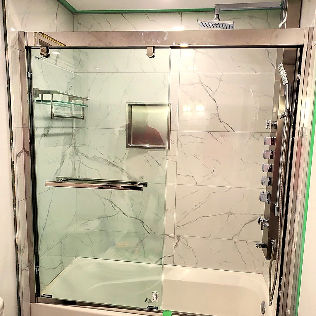 Glass-enclosed shower with marble-look tile, rainfall head and chrome body jets