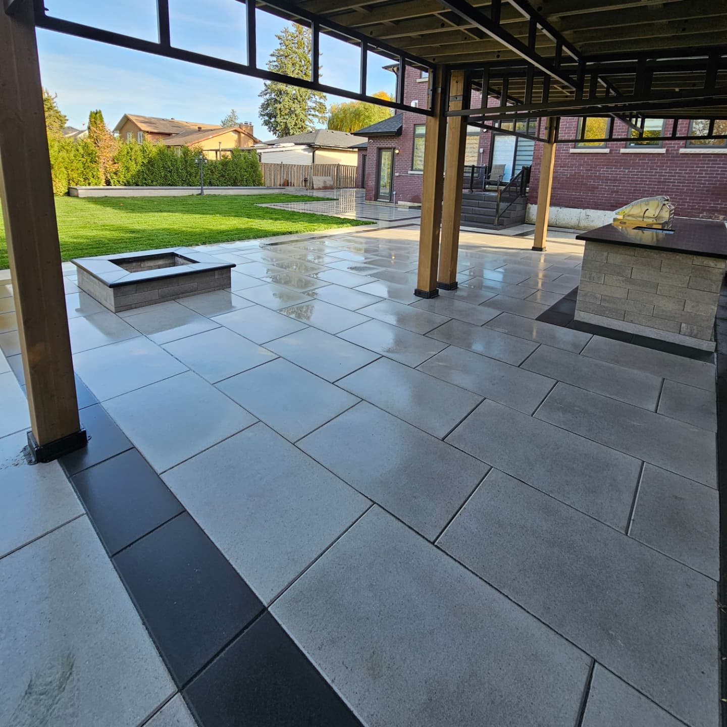 Interlocking stone patio with cedar pergola, fire pit and outdoor kitchen in Durham Region