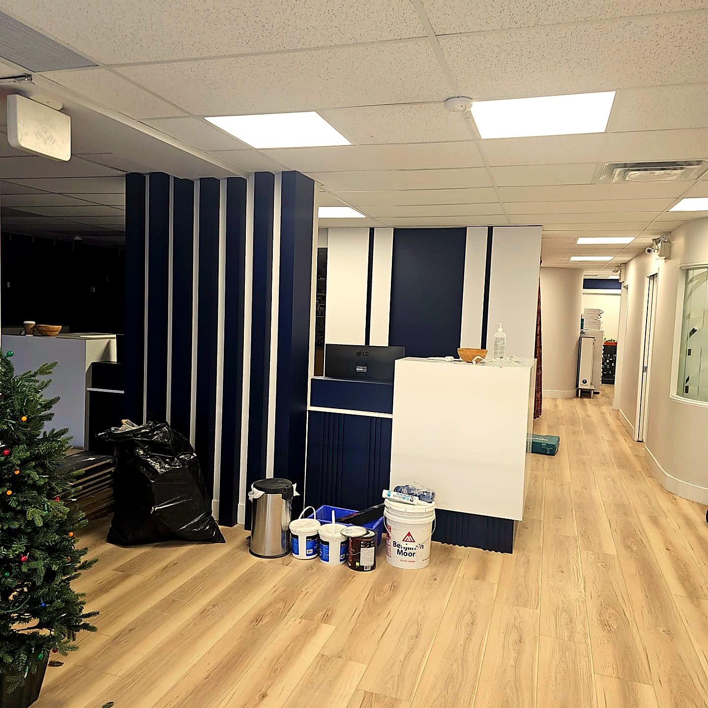 Completed commercial lobby with light wood flooring and modern blue accent wall